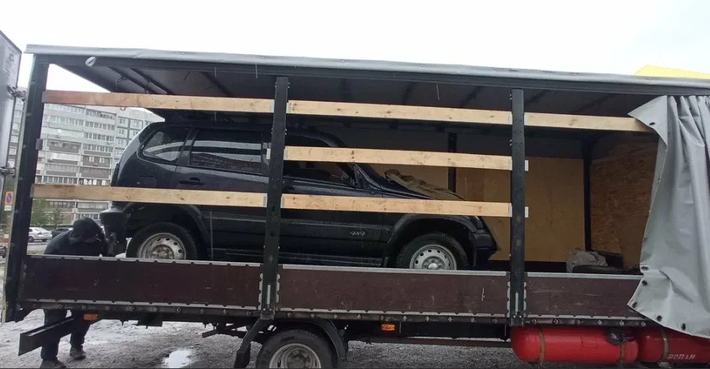 Внедорожник в кузове, закреплённый деревянными распорками