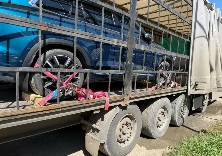 Колёса автомобиля в кузове, притянутые ремнями к полу